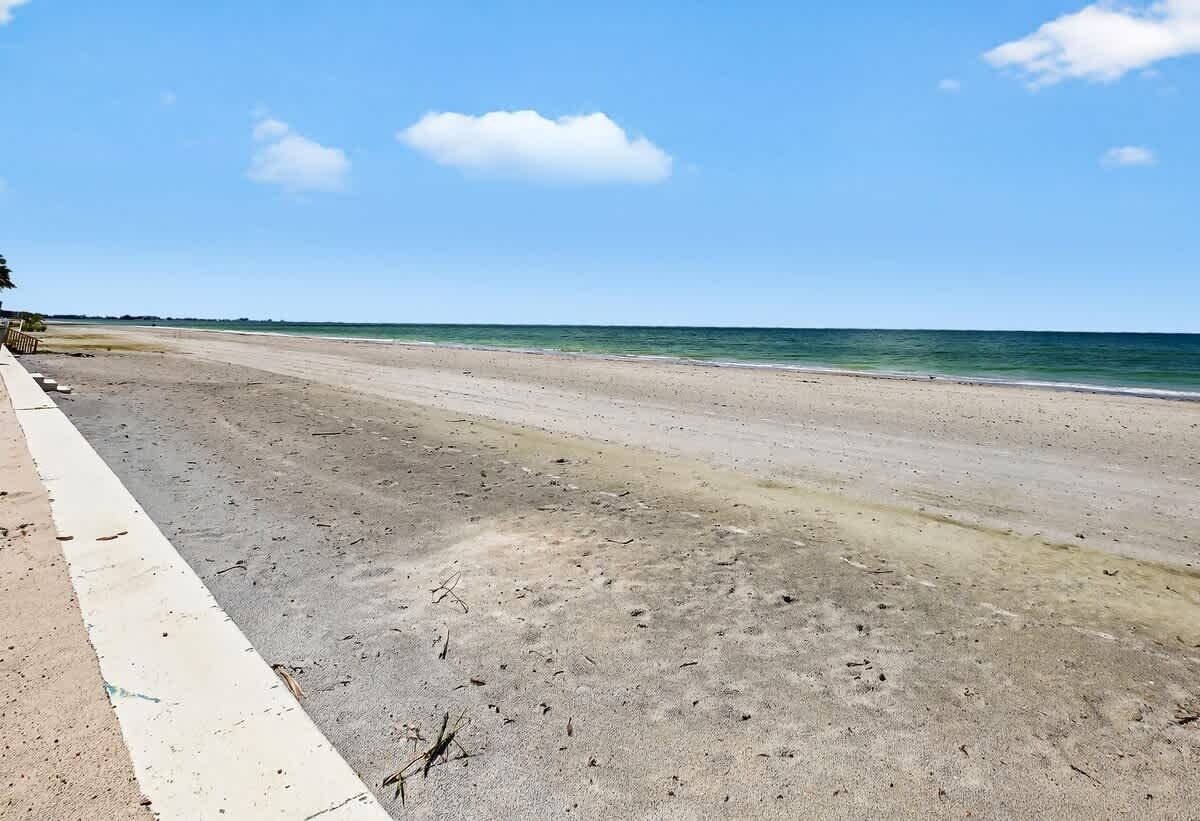 Une plage avec un ciel dégagé et une mer calme.