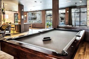 A pool table in a modern indoor setting with a bar area and seating. - Boulevard Stays Roomy 3BR Stay Pool, Parking, Fitness B (Richardson)