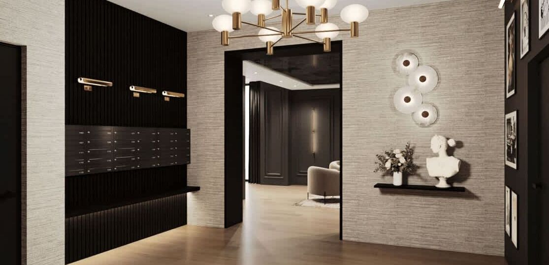 A modern interior with a wooden reception desk, a chandelier, and a wall-mounted light fixture.