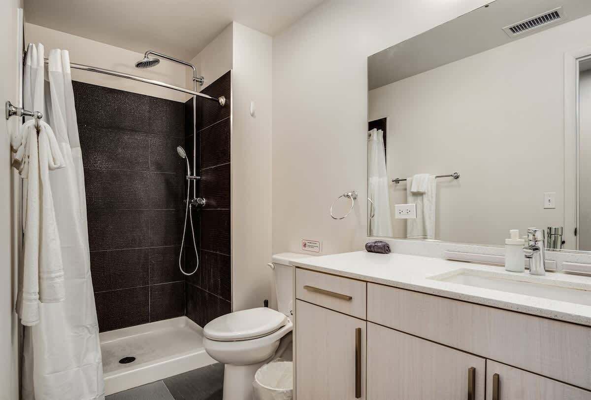 Une salle de bain moderne équipée d’une douche, de toilettes et d’un meuble-lavabo.