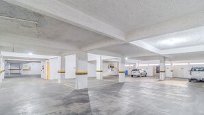 A parking garage with concrete pillars, yellow lines, and a few parked cars. - Apartamento 70m del mar Cerca de Todo en BC Pol406 (Balneário Camboriú)