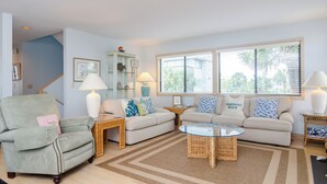 A living room with two sofas, a chair, a coffee table, and a lamp.