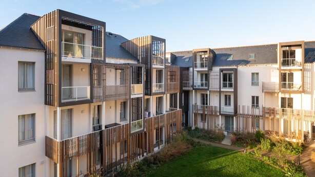 A modern multi-story residential building with balconies, a small garden area, and a clear sky. - Apartment 'Regard Marin - 4 People' with Balcony (Le Palais)