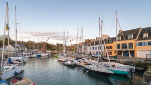 A marina with various boats docked, buildings with shops, and a clear sky. - Apartment 'Regard Marin - 4 People' with Balcony (Le Palais)