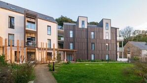 A modern residential building with multiple balconies, a paved pathway, and a well-maintained lawn. - Apartment 'Regard Marin - 4 People' with Balcony (Le Palais)