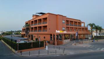 Un hotel de varios pisos con techo plano, balcones y un cartel que indica que es un hotel de 5 estrellas.