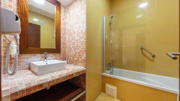 Un baño con lavamanos, espejo y ducha.