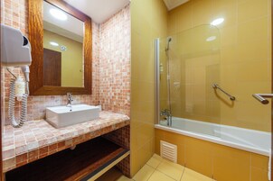 A bathroom with a sink, mirror, and shower.