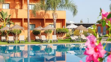 Een seizoensgebonden buitenzwembad, parasols voor strand/zwembad