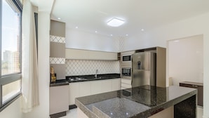 Una cocina moderna con encimera de granito, electrodomésticos de acero inoxidable y un salpicadero decorado.