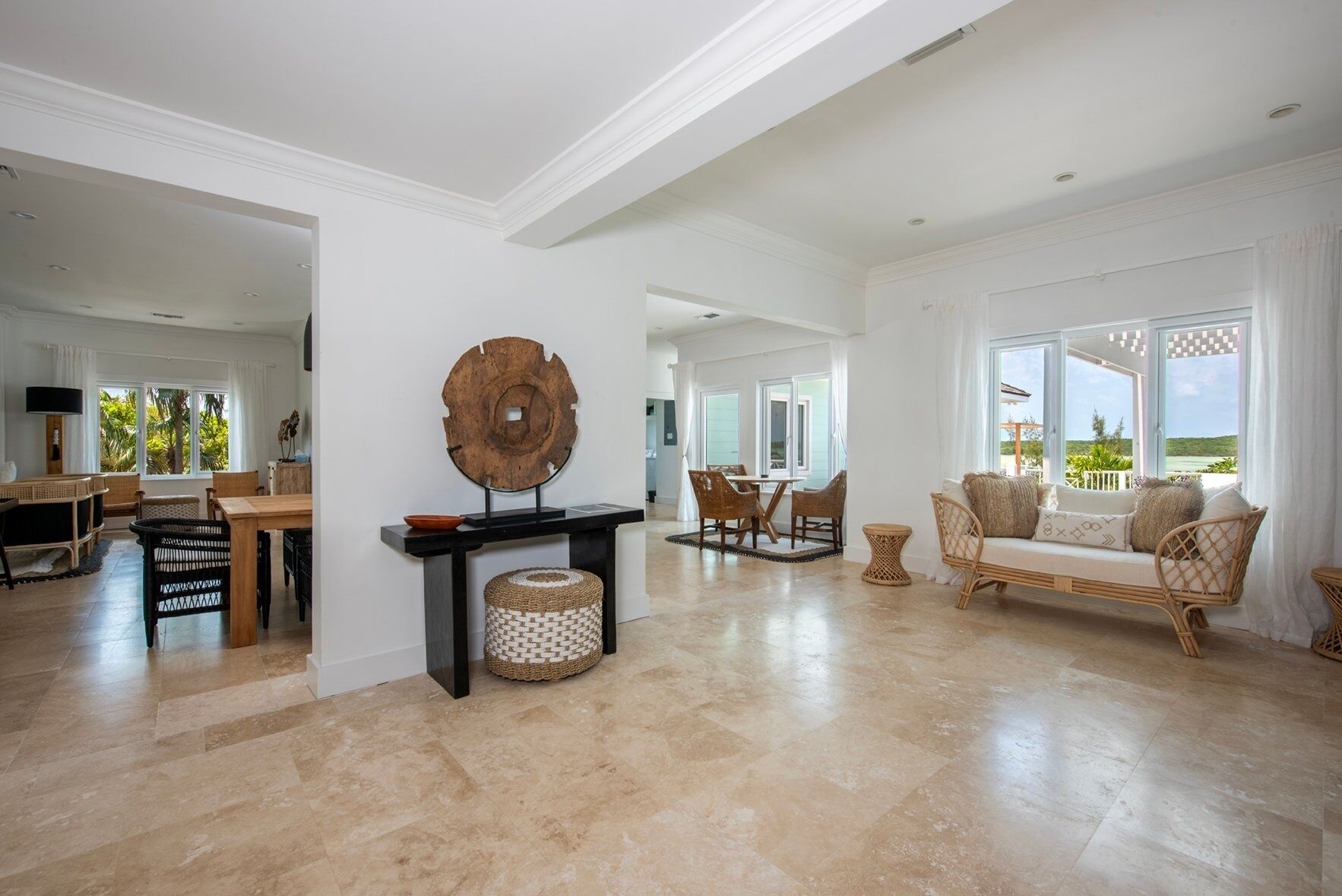Amplia sala de estar con una mesa de comedor, un sofá y un gran ventanal con vistas al exterior.