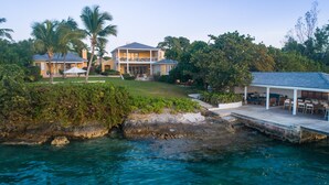 A coastal property with a large house, a covered patio, and a rocky shoreline. - Beehive Harbour Island. Luxury Dream World On The Bay. Private D 5 Bedroom Home (Dunmore Town)