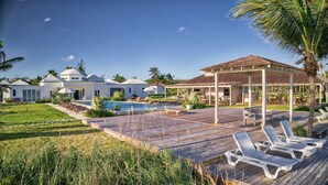 Un resort con piscina, sillas de descanso y un patio cubierto.