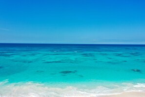 Ein klarer Blick auf ein türkisfarbenes Meer mit einem Sandstrand.