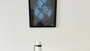 Ein moderner Esstisch mit Glasplatte, schwarzen Stühlen und einer Ablage mit weißen Behältern und einem Thermos.
