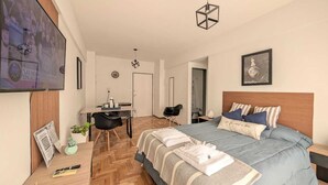 Ein modernes Schlafzimmer mit Bett, Nachttischen, Schreibtisch und Stuhl.