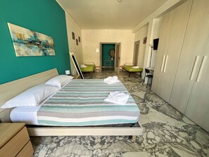 A hotel room with a bed, a desk, a chair, and a wardrobe. - Spacious 3 Bedrooms with Balcony&AC in Vaticano (Roma)