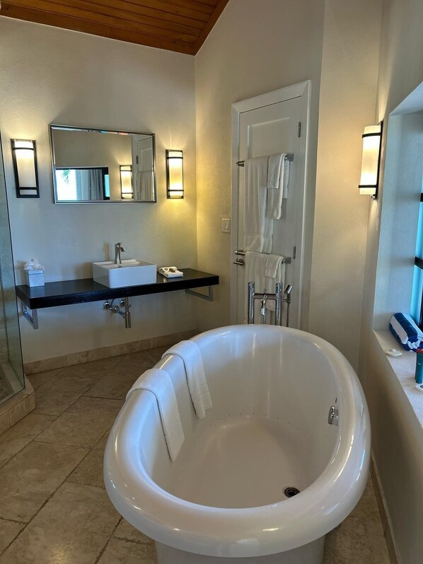 A modern bathroom with a freestanding bathtub, a vanity with a mirror and lights, and a shower area. - Sky Beach Club Bungalow 3 Steps From Beach W/ Club, Pool 1 Bedroom Bungalow (Governor's Harbour)