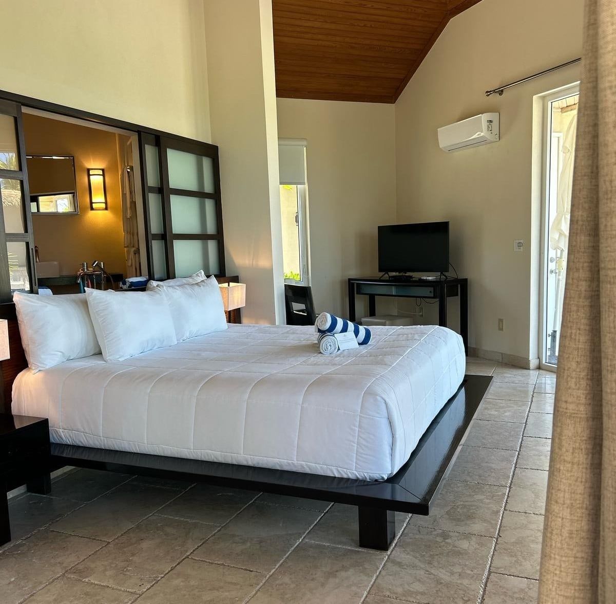 Une chambre d’hôtel avec un grand lit, une télévision et une fenêtre.