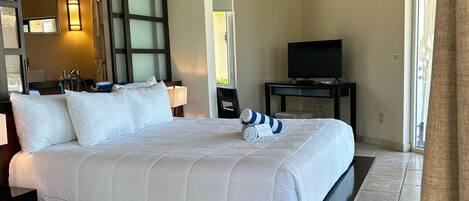 Une chambre d’hôtel avec un grand lit, une télévision et une fenêtre.