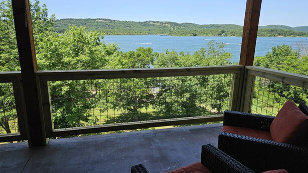 Un espace extérieur abrité offrant une vue sur un lac et des collines.