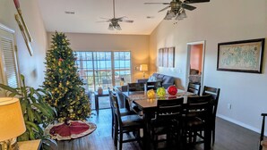 Un coin repas avec une table en bois, des chaises et un sapin de Noël.