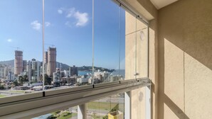 Un immeuble de grande hauteur offrant une vue sur le paysage urbain, avec plusieurs gratte-ciel et une étendue d’eau.