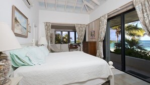 A bedroom with a bed, a desk, and a view of the ocean. - Hohum - Private Beachfront House On Exclusive Windermere 3 Bedroom Home (Savannah Sound)