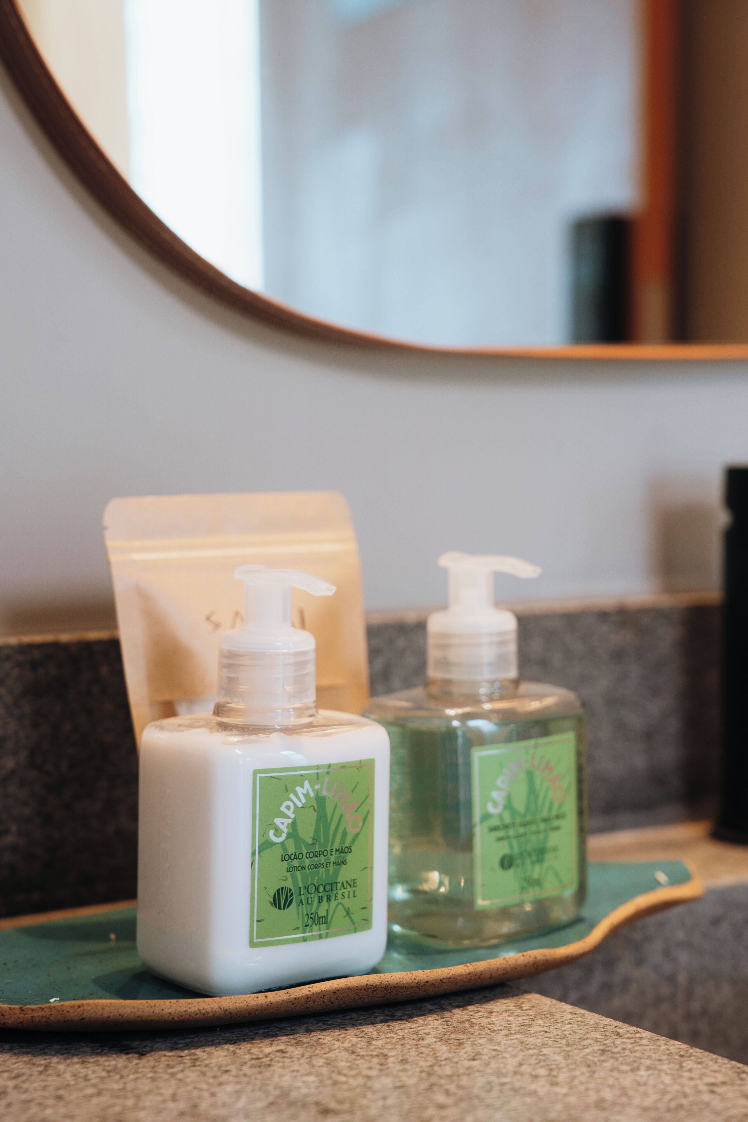 A bathroom counter with two bottles of lotion and a soap dish.