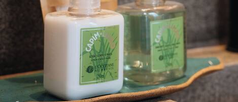 A bathroom counter with two bottles of lotion and a soap dish.