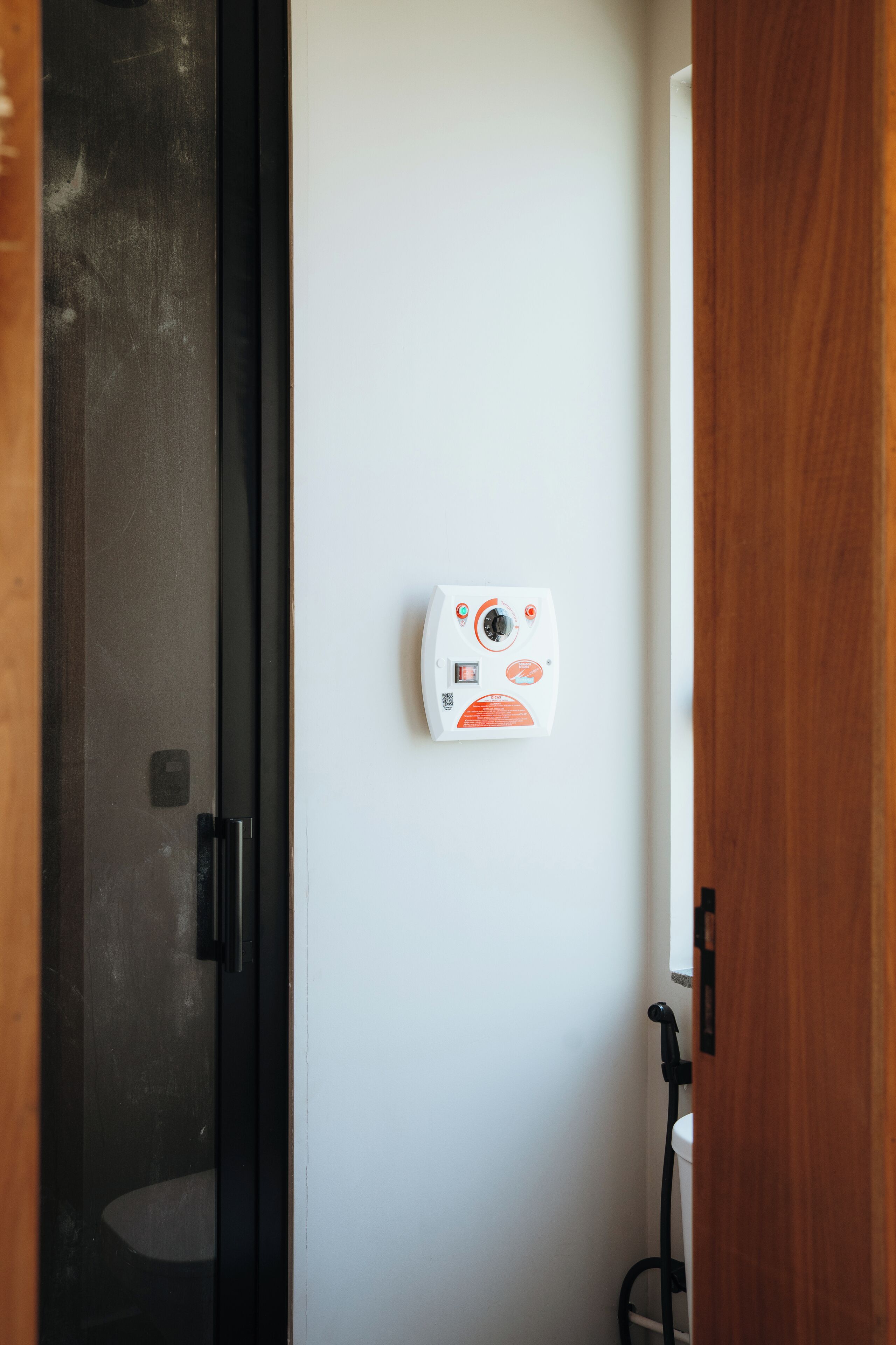 A white wall with a security camera and a black door frame.