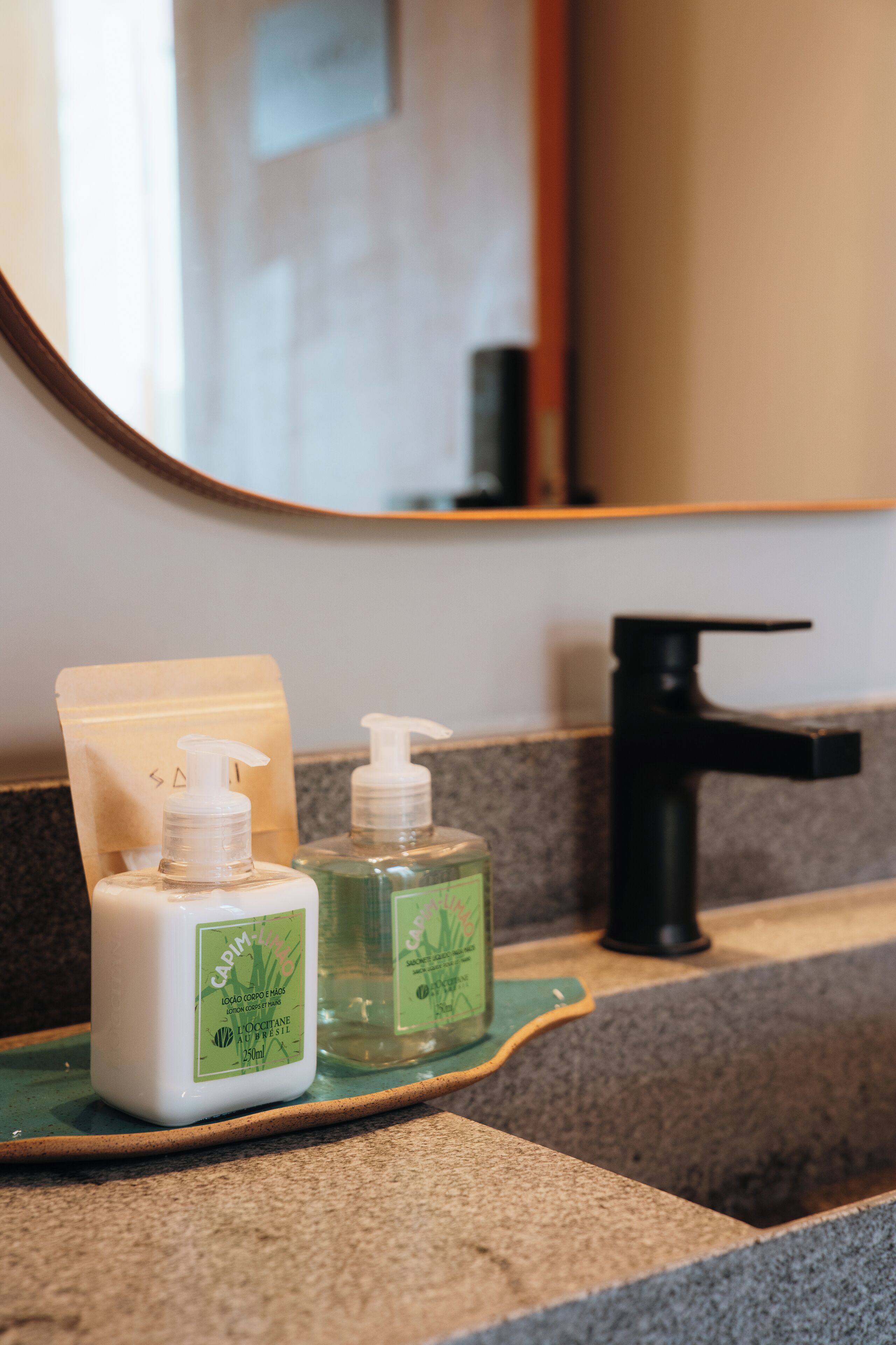 A bathroom counter with two bottles of hand soap and a soap dispenser.