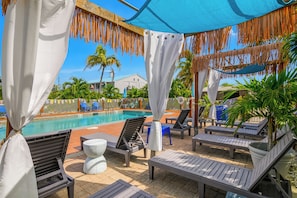 A poolside area with lounge chairs, a small table, and a clear view of the pool.