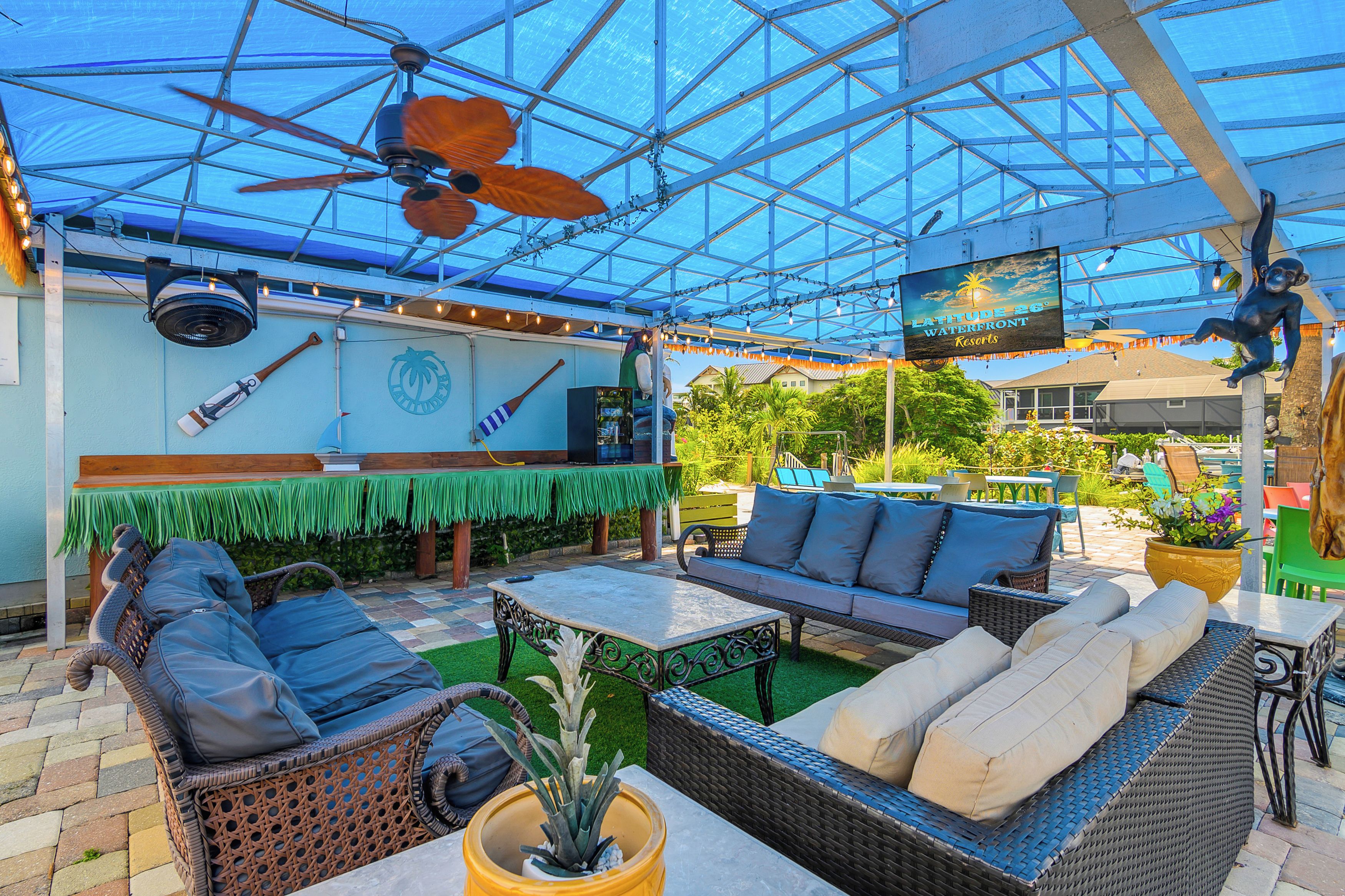 An outdoor patio with wicker furniture, a ceiling fan, and a sign indicating a waterfront location.