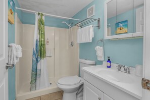 A bathroom with a shower, toilet, sink, and a towel rack. - Tropical King Studio in Fort Myers Beach (Fort Myers Beach)