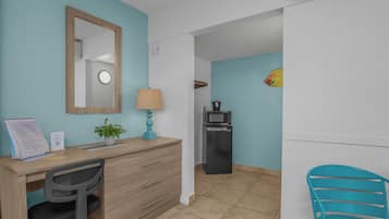Habitación de hotel con escritorio, silla y microondas.