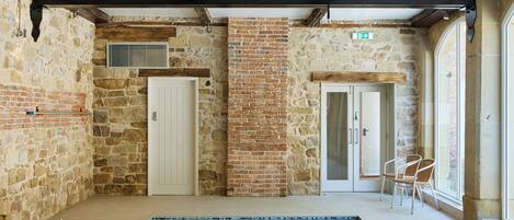 A pool area with stone walls, wooden beams, and a tiled floor.