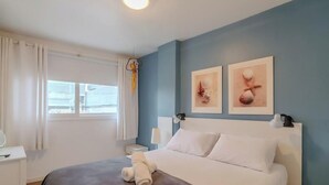 A hotel room with a bed, a bedside table, a lamp, and two wall-mounted artworks. - 3BR apt Near Beach w/ Garage in Picarras Nra0490 (Picarras)