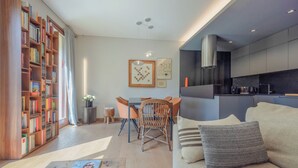 Een moderne woonkamer met een bank, een eettafel en een boekenkast.