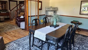 A dining room with a wooden table, chairs, and a chandelier. There is a staircase leading to another room. - Glenrock Cottage -  charming 4-bedroom house in Glenrock WY (Glenrock)