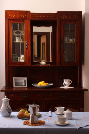 Ein Essbereich mit einer Holzkabine, einem Tisch gedeckt mit Tellern, Tassen und einer Kaffeekanne.