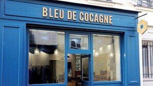 A storefront with the sign "BLEU DE COCAGNE" and large glass windows.
