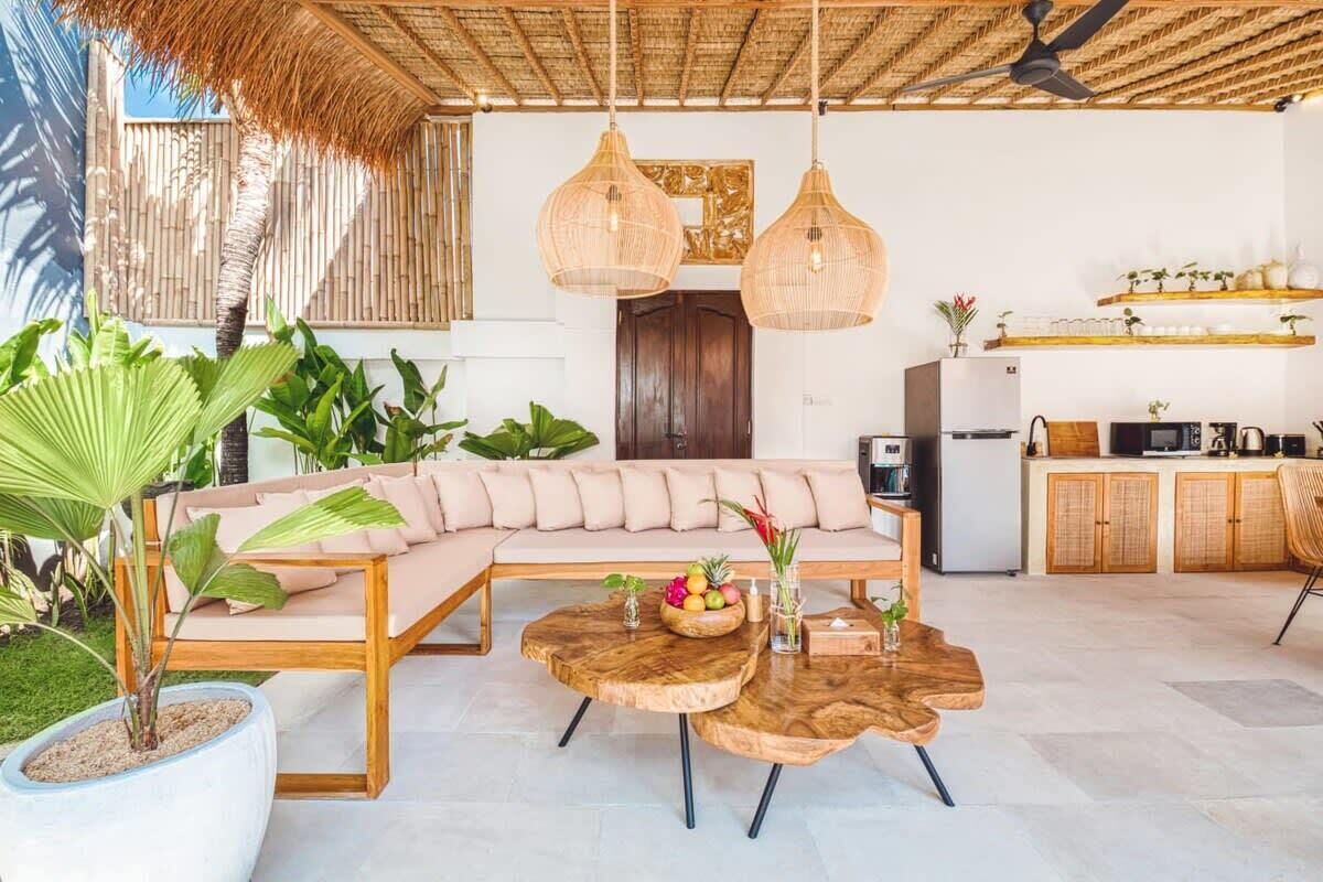 A modern living area with a sofa, wooden coffee table, and hanging wicker lamps.