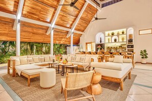 A spacious living area with a high ceiling, wooden beams, and a large sofa set. - Villa Manhattan - Luxurious 8-BDR Villa, huge pool (Kecamatan Kuta Utara)