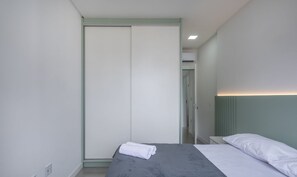 Ein Schlafzimmer mit einem Bett, einem Kleiderschrank und einem Nachttisch.