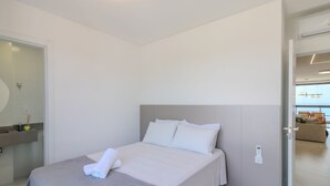 Ein modernes Hotelzimmer mit Bett, Bad und Blick auf die Stadt.