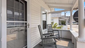 A porch with two chairs, a table, and a door with a glass panel. - Clam Cove - Heart of Hampton Beach! (Hampton)