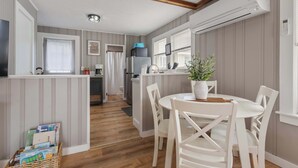 A compact kitchen with a refrigerator, microwave, and a small dining area with a table and chairs.
