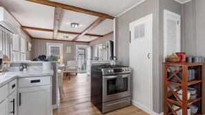 Eine Küche mit Herd, Backofen und Holzbalken an der Decke.