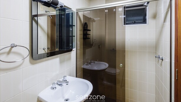 A bathroom with a sink, mirror, and glass-enclosed shower area. - Apt w Balcony Close to Beach Privileged loc Mrn302 (Balneário Camboriú)